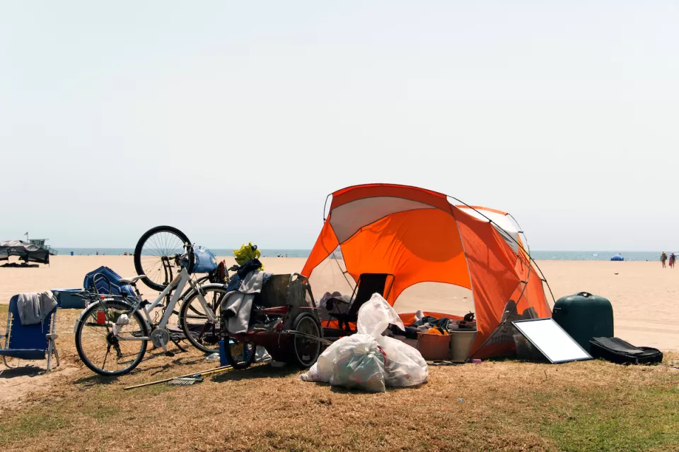 Orange tent and bicycles belonging to unhoused people at Venice Beach, California